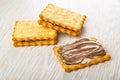 Sandwiches from crackers with chocolate-dairy paste on wooden table